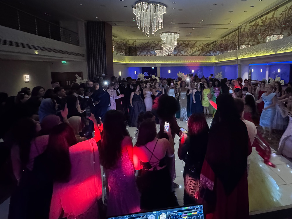 Martin at the DJ booth looking out over a full dancefloor in a chandeliered function room
